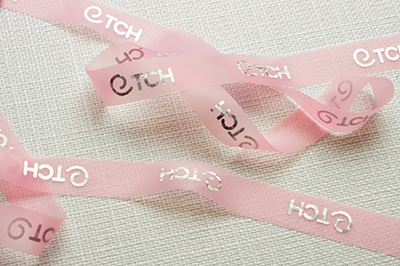 Полупрозрачные ленты: розовая с серебристыми логотипами