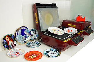 2 вакуумных аппарата с образцами отпечатанных тарелок с яркими принтами