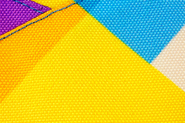 Отпечаток желто-голубых прямоугольников на крупно фактурной ткани