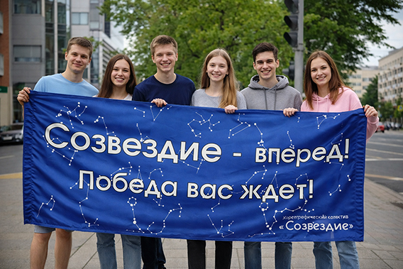 Синий транспарант с белыми надписями и созвездиями в руках молодежной группы