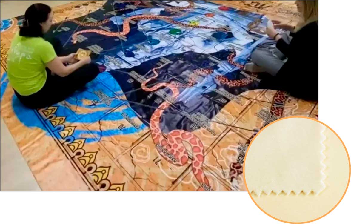 Игроки сидят на полу на игровом поле, напечатанном на бархате