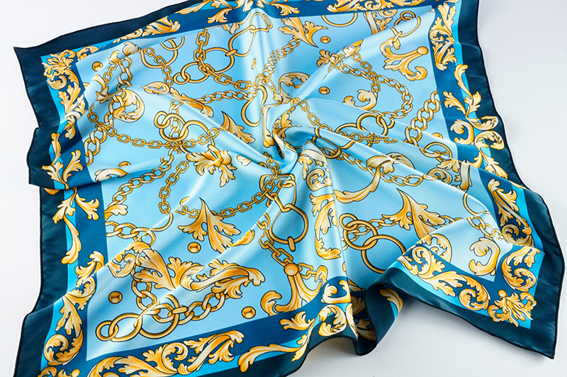 Отпечаток орнамента из золотых цепей на голубом фоне, оптимально насыщенный, на шелке Армани с нежными складками