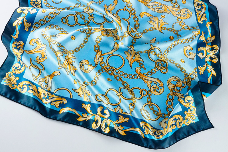 Блестящий, насыщенный отпечаток орнамента из золотых цепей на голубом фоне на шали из шармуса