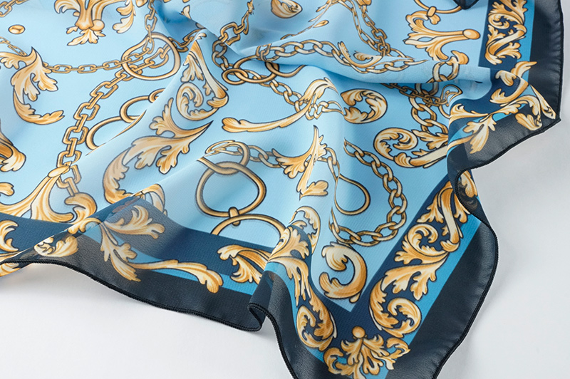 Отпечаток орнамента из золотых цепей на голубом фоне в пастельных тонах, на шифоне с воздушными складками