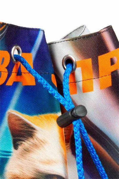 Голубой шнур, выходящий через два люверса в верхнем крае сумки, зафиксирован стопором