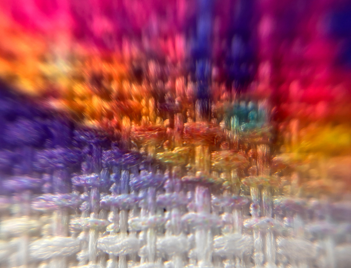 Макрофото белой ткани с фрагментом яркой цветной печати