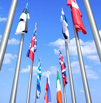 Яркие флаги на высоких вертикальных флагштоках на фоне неба