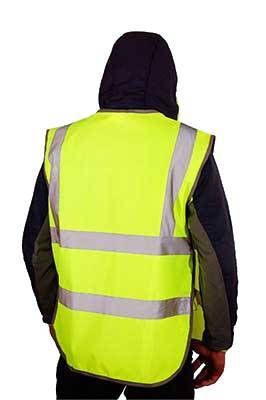 Строитель в ярком желтом сигнальном жилете с тремя светоотражающими полосами, вид сзади