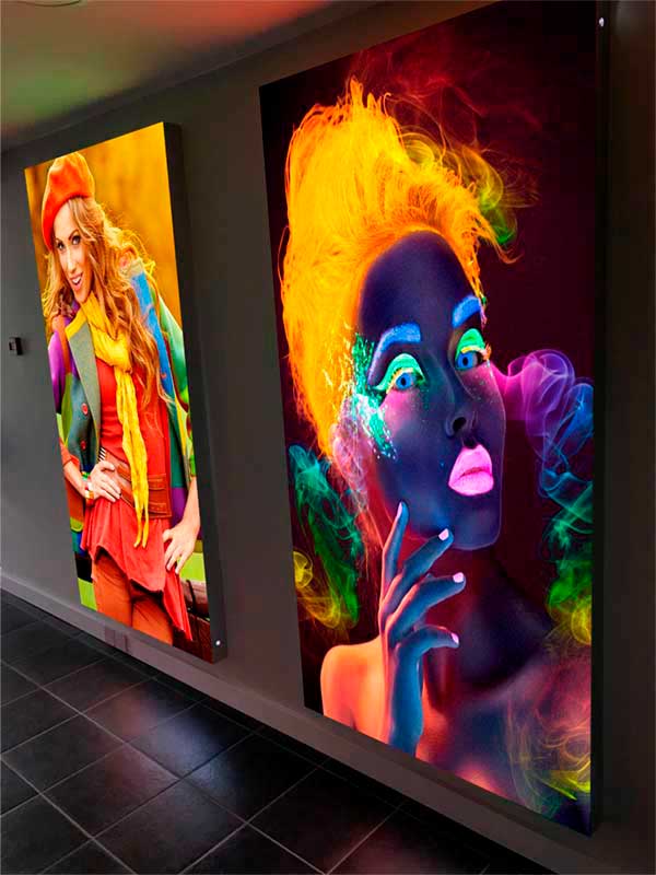 Два световых короба с яркими, четкими дизайнами на стене помещения.