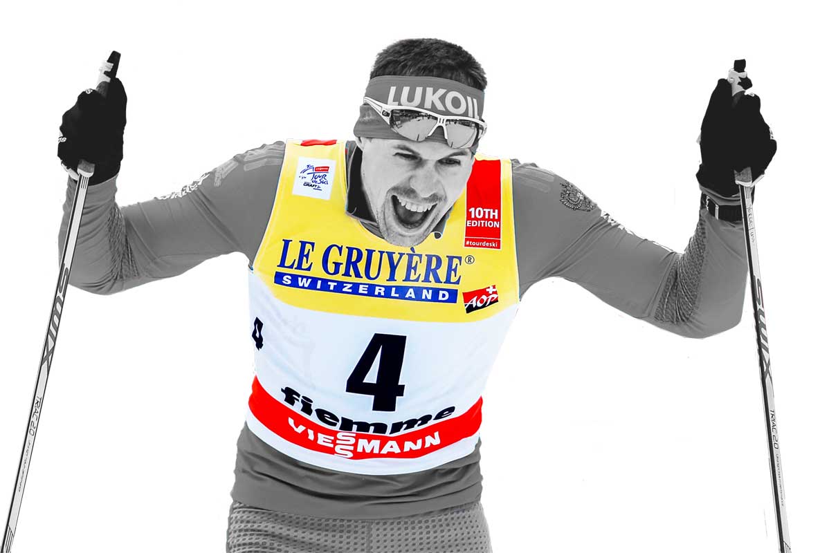 Лыжник гонщик в майке с номером, с яркой рекламой и логотипами спонсоров